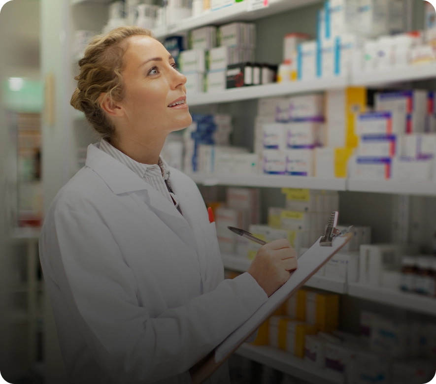 Pharmacist checking inventory on pharmacy shelves.