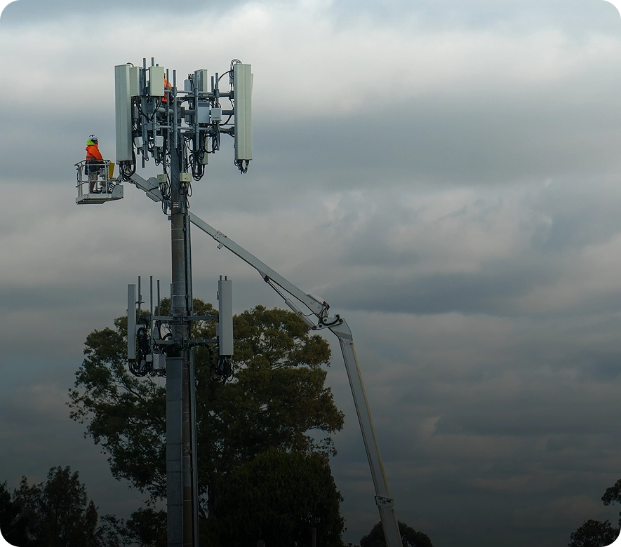 Worker on lift near cell tower.