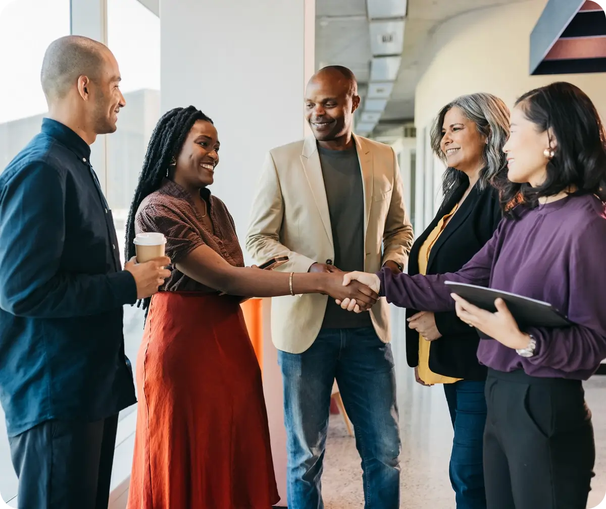 People shaking hands in a business setting.
