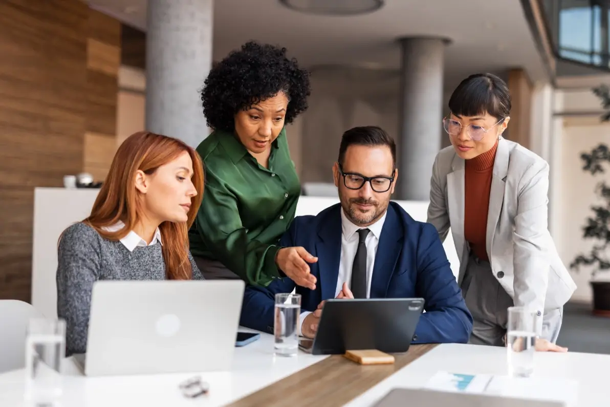 Group collaborating around a tablet in office.