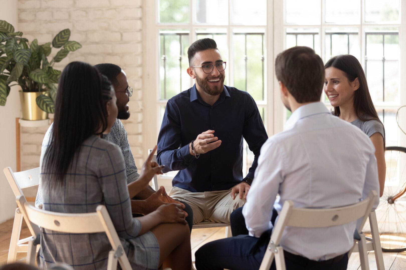 A group of professionals engaged in a lively discussion in a bright office.