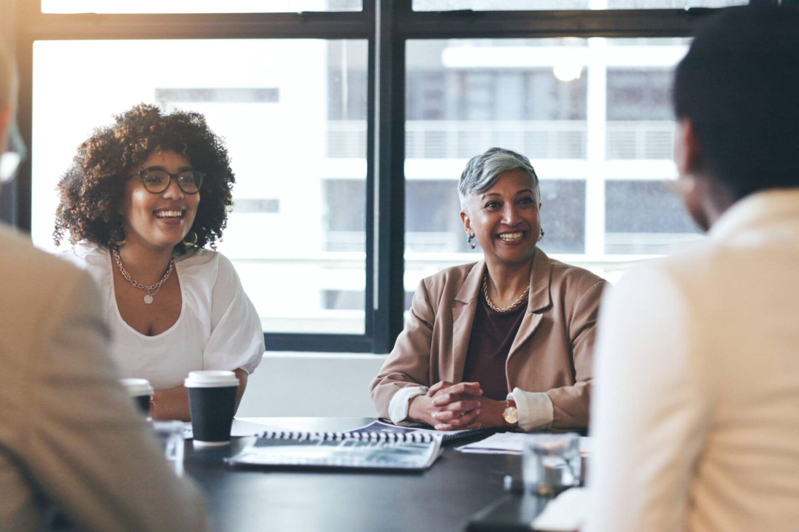 Three professionals engaged in a meeting around a conference table.